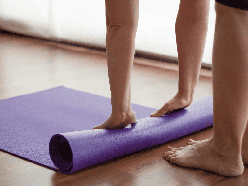Yogi rolling up a yoga mat